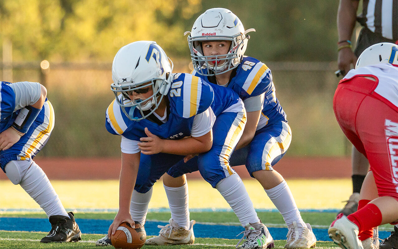 A Piedmont Youth Football Player hikes the ball. 