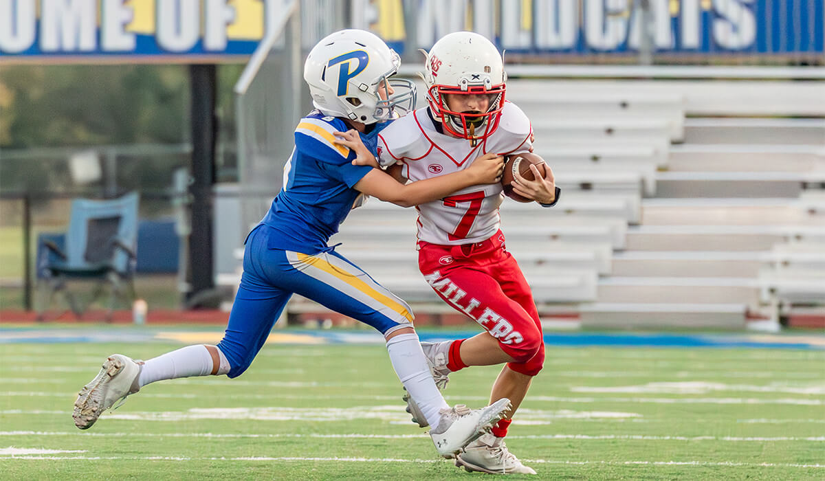 A Piedmont Youth football player tackling a player from the opposing team. 