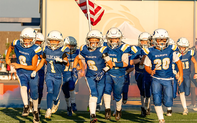 The Piedmont Youth Football team running onto the field. 