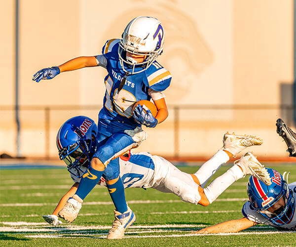 A Piedmont Youth football player running with the ball in hand. 